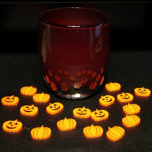 Load image into Gallery viewer, Orange acrylic pumpkins and jack-o'-lanterns surround a red votive. Displayed on a black background.