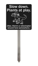 Load image into Gallery viewer, Velociraptor Garden Sign – “Slow Down, Plants at Play” – Laser Engraved Dinosaur Yard Stake
