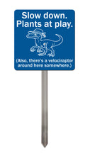Load image into Gallery viewer, Velociraptor Garden Sign – “Slow Down, Plants at Play” – Laser Engraved Dinosaur Yard Stake
