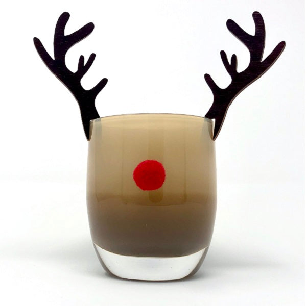 Wooden antlers adorn a brown votive. A red puff is on the front of the votive to simulate Rudolph the Red Nosed Reindeer. Votive shown on a white background. 